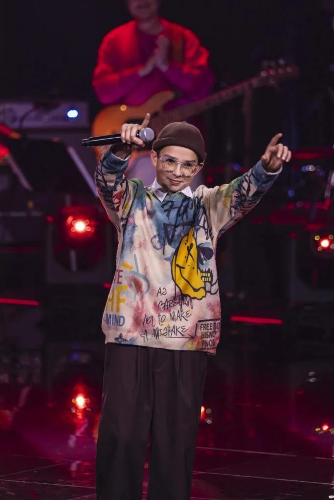 Ein Jugendlicher steht auf der Bühne.